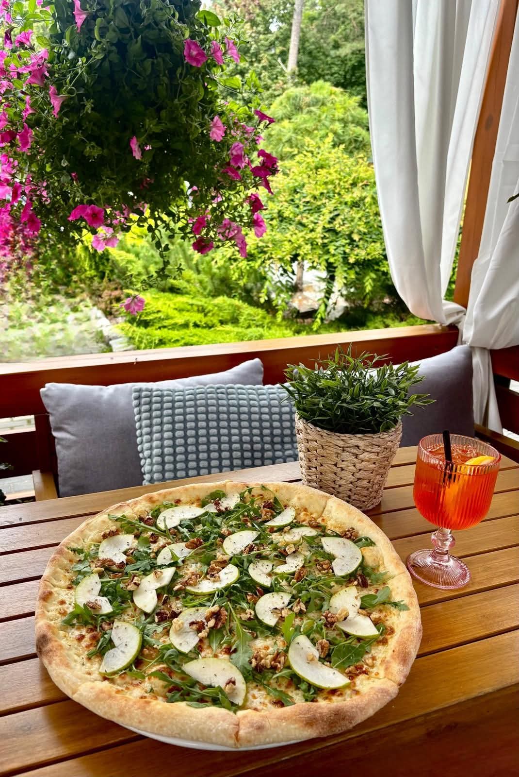 Pizza Włoska z gruszką i rukolą na letnim tarasie wśród kwiatów